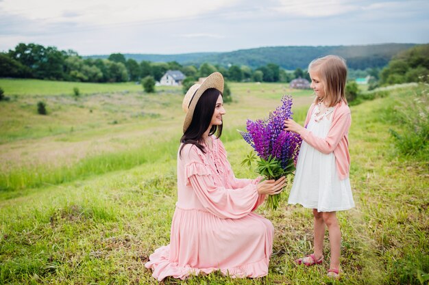 Heureuse femme et fille posent avec bouquet de lavande sur le terrain