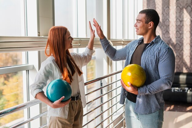 Heureuse femme et homme tenant des boules colorées