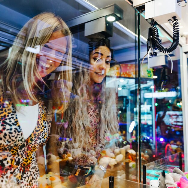 Heureuse femme jouant à la machine d'arcade