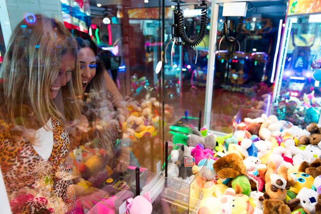 Heureuse femme jouant à la machine d'arcade