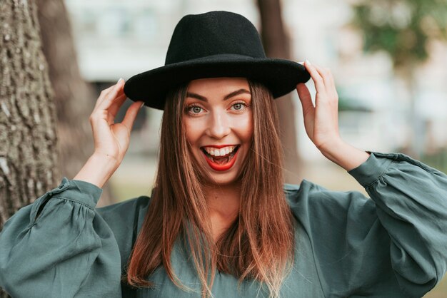 Heureuse femme portant un chapeau noir