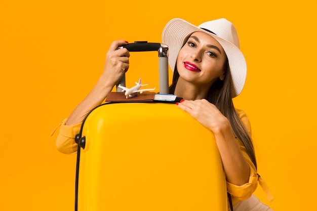 Heureuse femme posant avec des bagages et être prêt pour les vacances