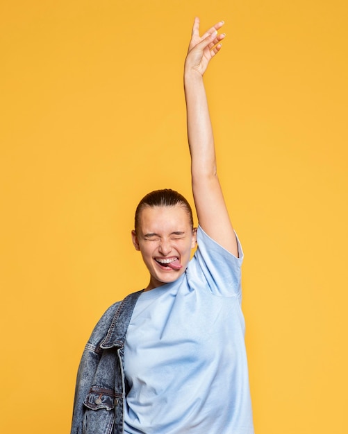 Photo gratuite heureuse femme posant avec veste en jean et langue