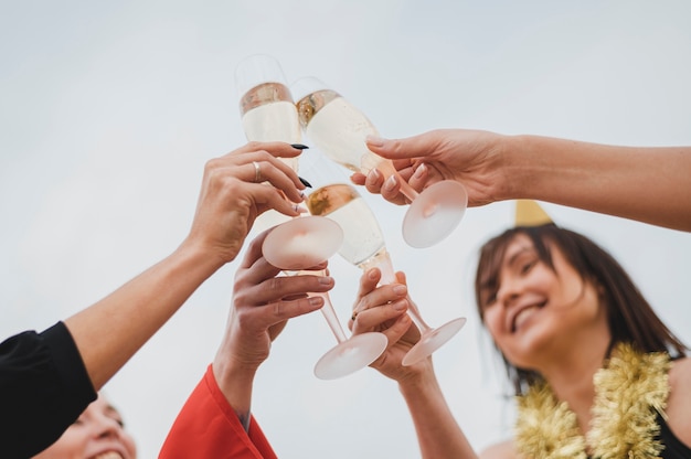 Heureuse femme réclame des coupes à Champagne à la fête sur le toit