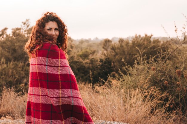 Heureuse femme rousse regardant la caméra