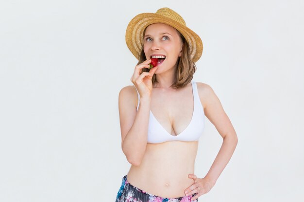 Heureuse femme sexy ludique en chapeau d'été et soutien-gorge