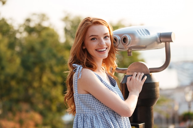 Heureuse femme souriante debout au télescope