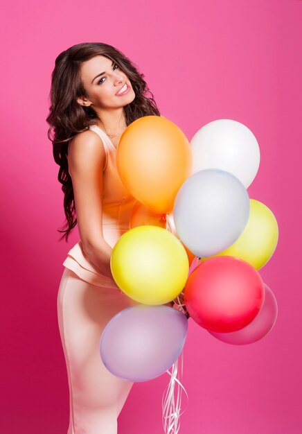 Heureuse femme tenant beaucoup de ballons