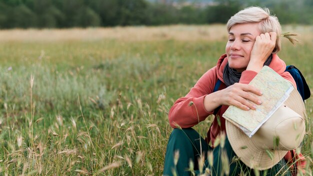 Heureuse femme de tourisme aîné à l'extérieur dans la nature