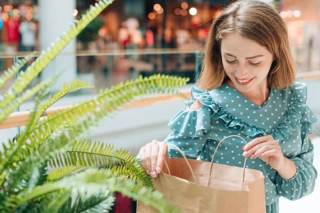 Photo gratuite heureuse femme vérifiant les sacs