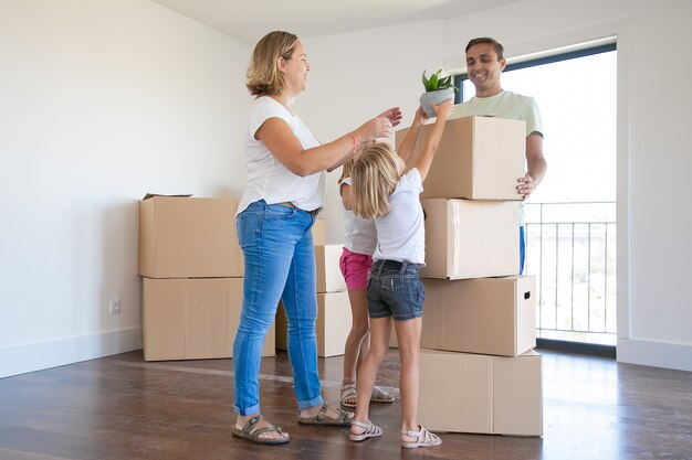 Heureuse jeune famille avec des boîtes de déménagement dans leur nouvelle maison