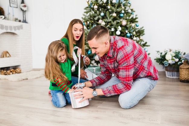 Heureuse jeune famille célébrant Noël ensemble