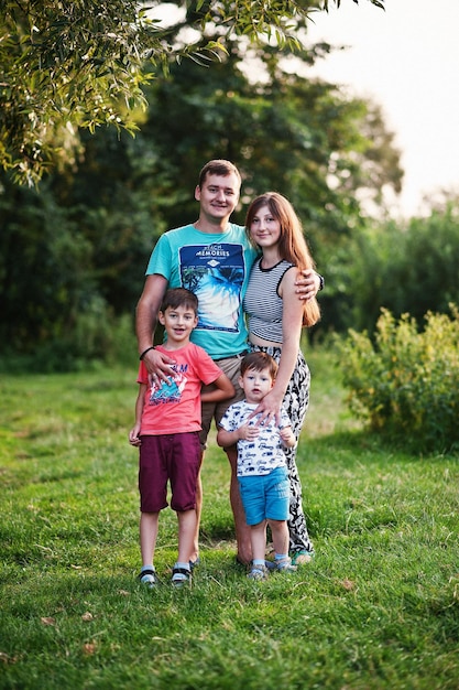 Heureuse jeune famille mère père deux enfants fils sur la nature s'amusant