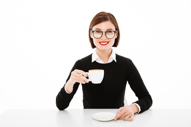 Heureuse jeune femme d'affaires avec une tasse de café