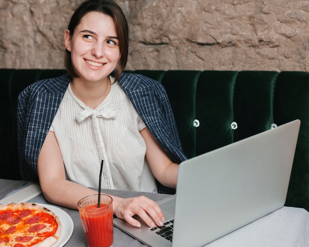 Photo gratuite heureuse jeune femme à l'aide d'un ordinateur portable