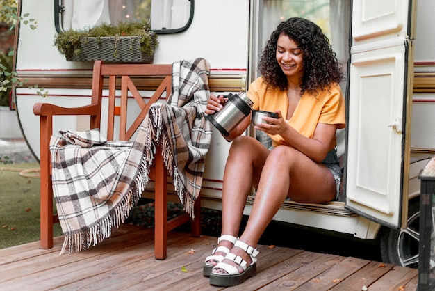 Photo gratuite heureuse jeune femme buvant du café sur un porche