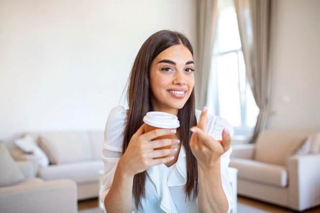 Heureuse jeune femme dans des écouteurs parlant en regardant un ordinateur portable prenant des notes étudiante parlant par vidéoconférence enseignante formatrice tutorat par webcam formation en ligne concept d'écoaching