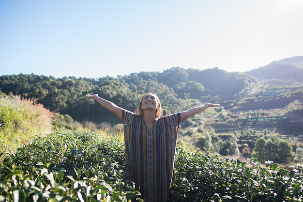 Photo gratuite heureuse jeune femme dans une plantation de thé