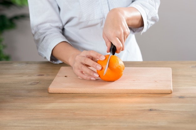 Heureuse jeune femme debout derrière le comptoir de la cuisine à la maison