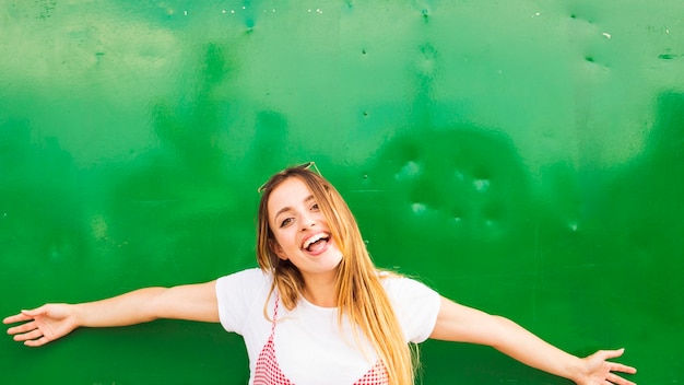 Photo gratuite heureuse jeune femme debout devant le fond vert