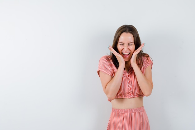 Heureuse jeune femme debout sur fond blanc