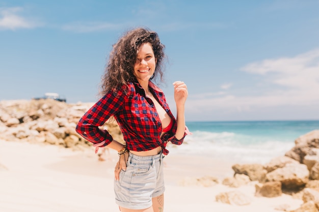 Heureuse jeune femme debout sur la plage