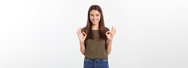 Heureuse jeune femme montrant signe ok avec les doigts un clin d'oeil isolé sur fond gris