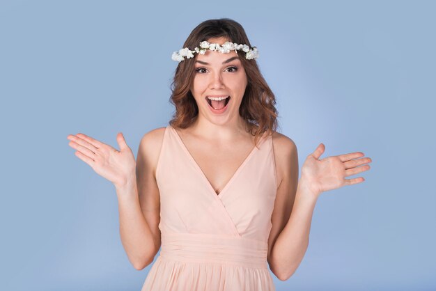 Heureuse jeune femme en pleurs en robe avec une couronne blanche sur la tête