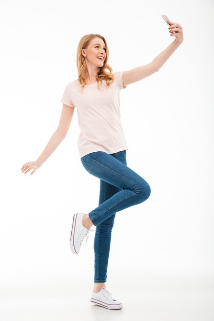 Heureuse jeune femme prendre un selfie par téléphone mobile.