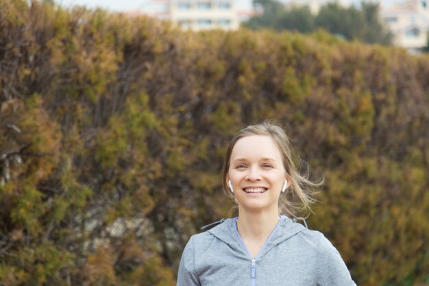 Heureuse jeune femme qui court dans le parc en automne