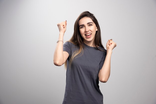 Heureuse jeune femme regardant la caméra avec un sourire joyeux et charmant