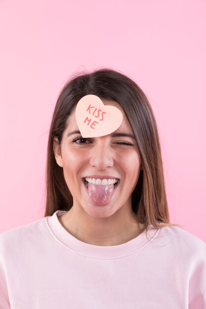 Heureuse jeune femme s&#39;amuser avec un coeur de papier sur le devant