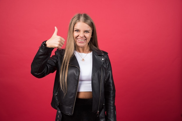 Heureuse jeune femme souriante montrant un geste du pouce vers le haut