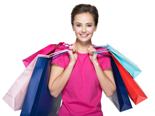 Heureuse jeune femme souriante avec des sacs après le shopping