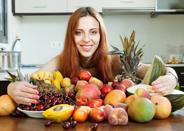 Heureuse Jeune Femme Avec Des Tas De Fruits