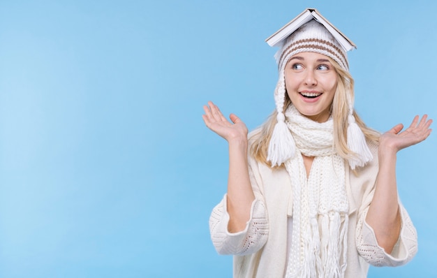 Heureuse jeune femme tenant un livre sur la tête