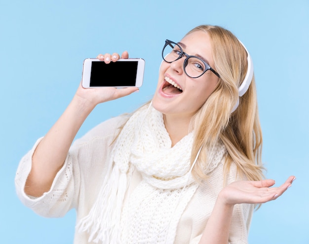 Heureuse jeune femme tenant un téléphone