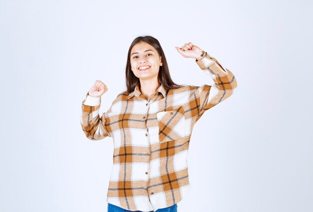 heureuse jeune fille posant avec les mains levées.