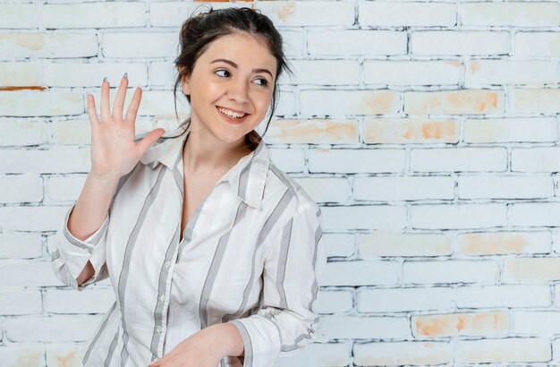 Heureuse jeune fille se sentant joyeuse et montrant sa main Photo de haute qualité