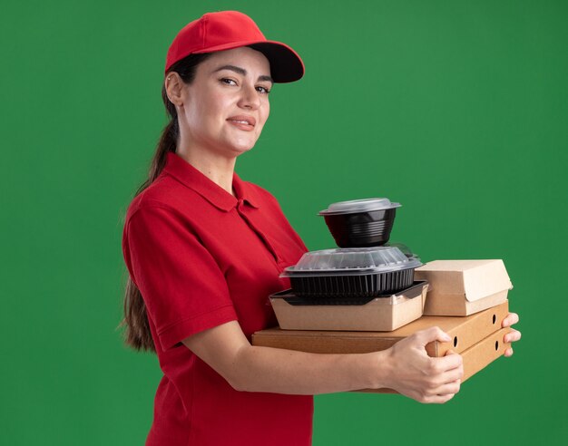 Heureuse jeune livreuse en uniforme et casquette