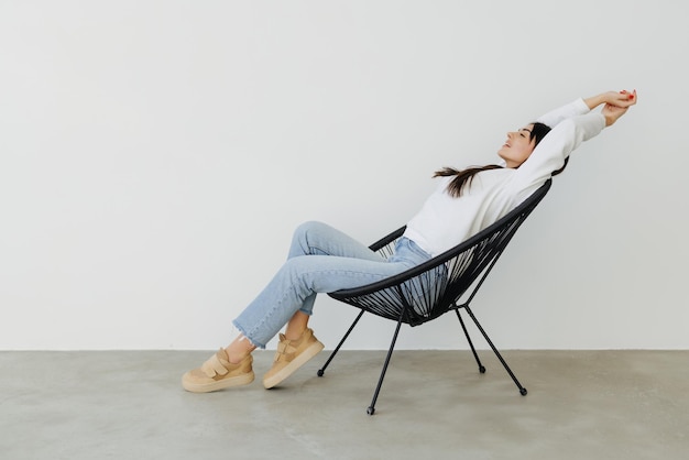 Heureuse jolie femme allongée dans le fauteuil le week-end