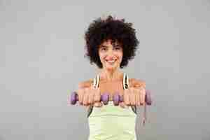 Photo gratuite heureuse jolie femme de remise en forme, faire de l'exercice avec des haltères