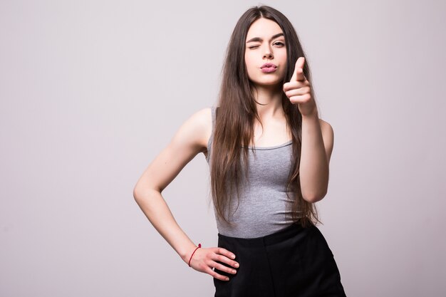 Heureuse jolie jeune femme debout et pointant