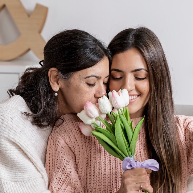 Heureuse maman et sa fille avec des fleurs