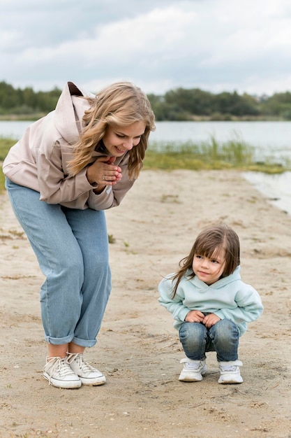 Photo gratuite heureuse mère et enfant sur le sable