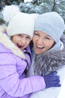Heureuse mère et fille, posant à l'extérieur en hiver