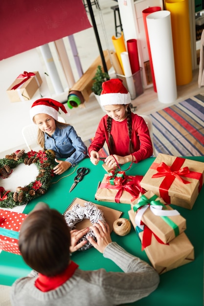 Heureuse mère et filles emballant des cadeaux de Noël