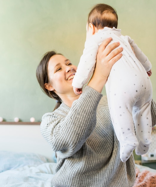 Photo gratuite heureuse mère jouant avec bébé