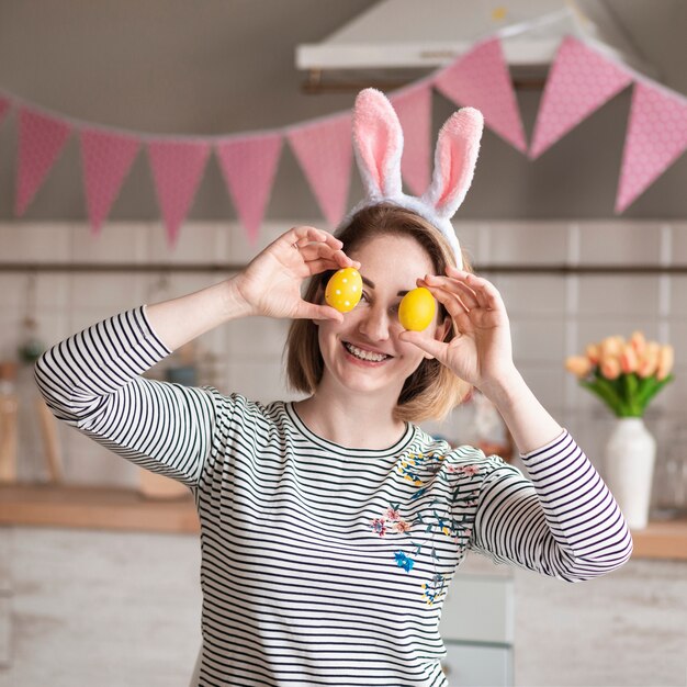 Heureuse mère avec des oreilles de lapin tenant des oeufs de Pâques