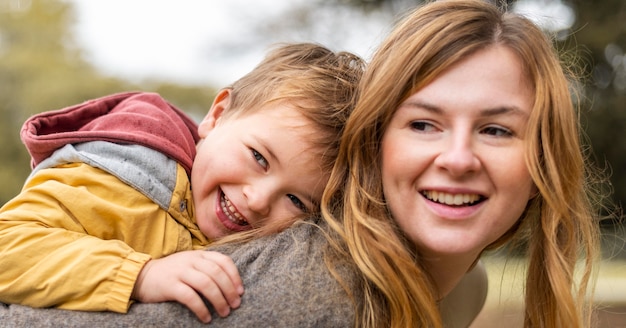 Photo gratuite heureuse mère tenant un enfant sur le dos